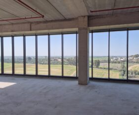 היחידה נמצאת בקומה גבוהה בבניין עם חלונות מסך שמשקיפים לשדות